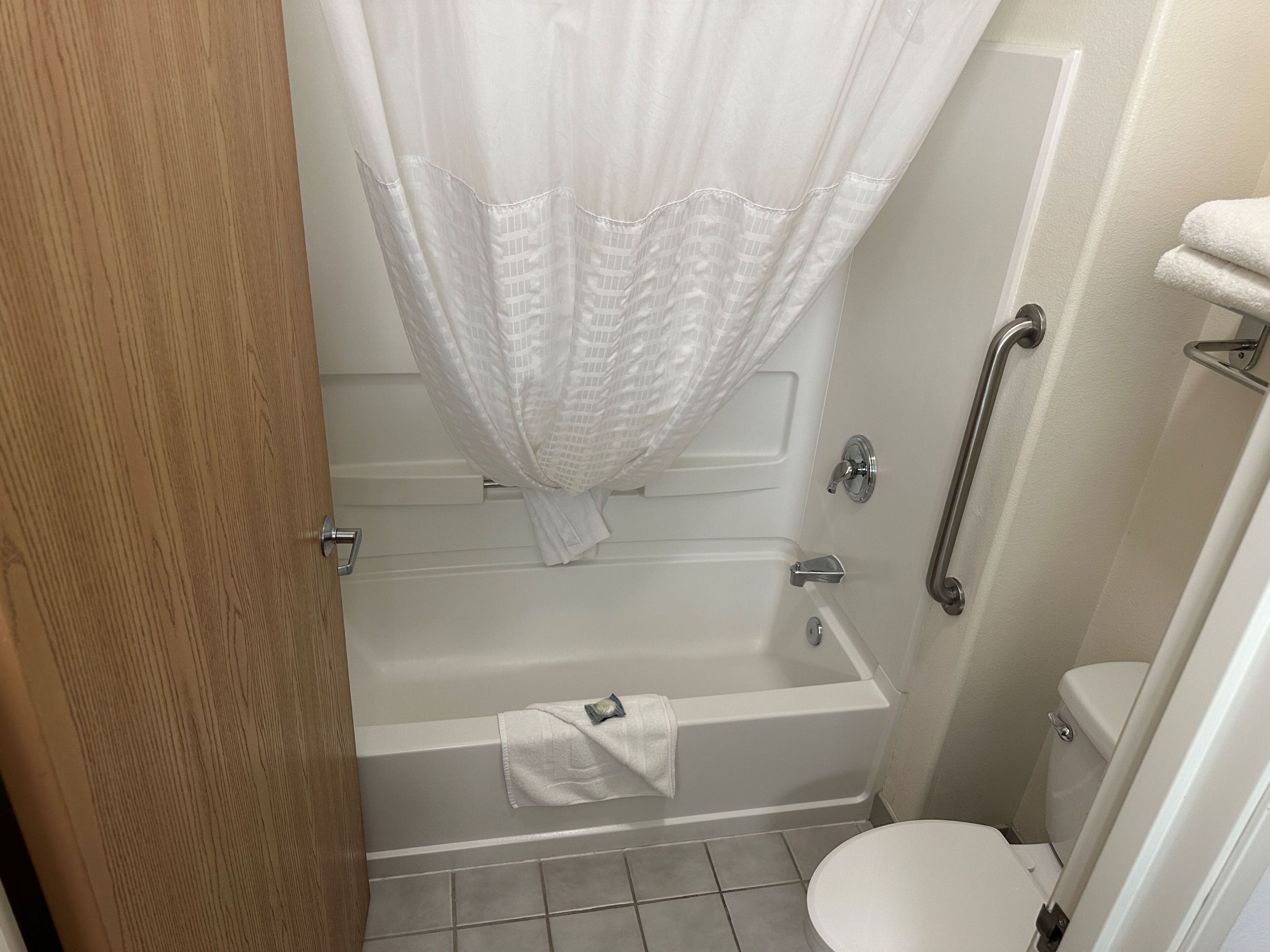 Une salle de bain avec une baignoire, des toilettes et un rideau de douche.