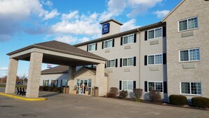 A multi-story hotel with a covered entrance and a sign indicating it is part of the Oak Hill Inn & Suites.