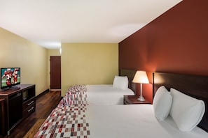 Une chambre d’hôtel avec un lit, une télévision, une lampe et un tapis à carreaux.