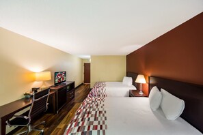 Ein Hotelzimmer mit Bett, Schreibtisch, Stuhl und Lampen.
