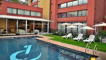 Una piscina al aire libre, tumbonas
