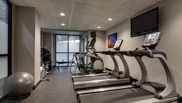 A fitness center with treadmills, a stationary bike, and a large exercise ball.