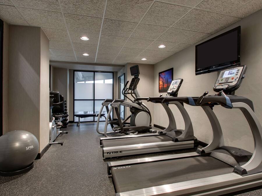 A fitness center with treadmills, a stationary bike, and a large exercise ball.