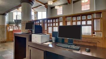 A reception desk with two monitors, a printer, and a keyboard.