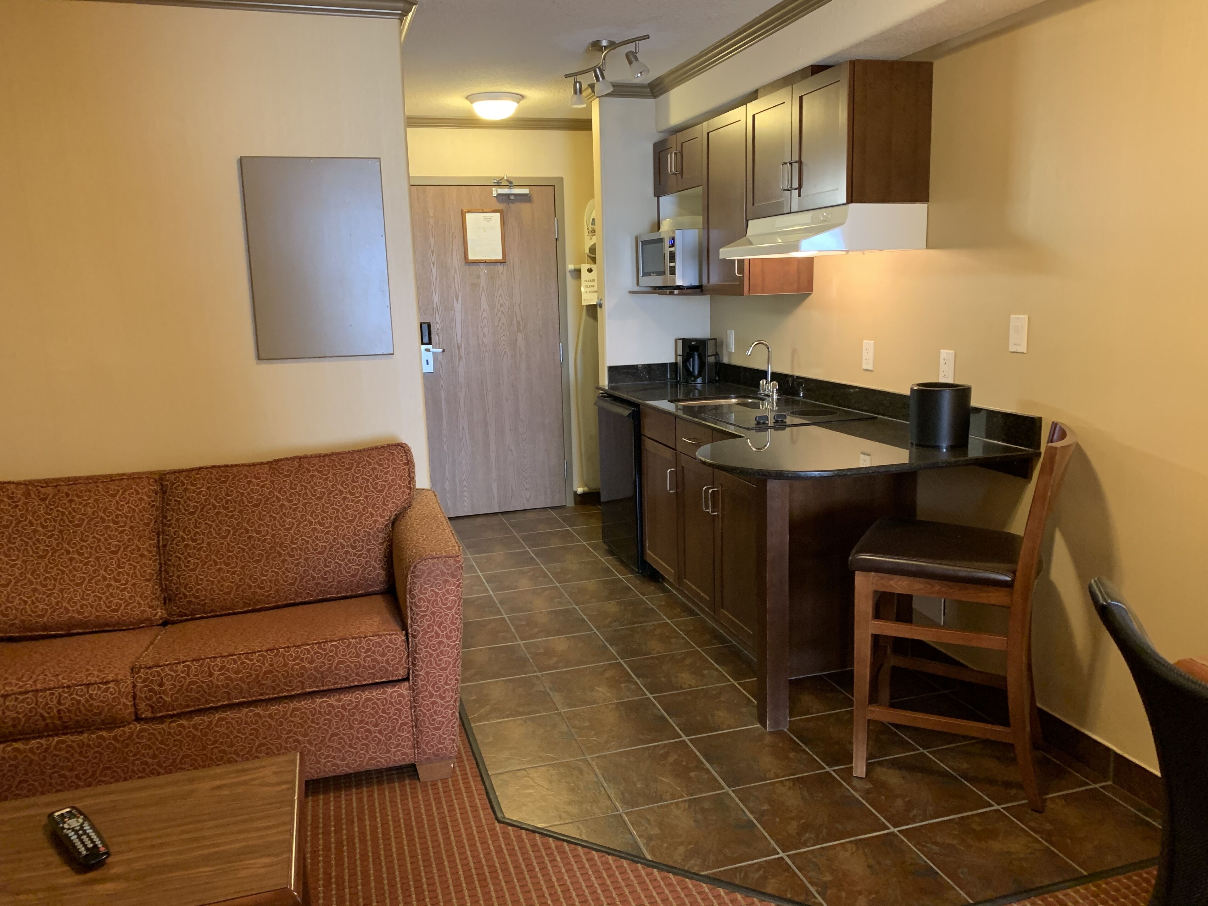 A compact living space with a kitchenette, a sofa, and a dining area.