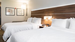 A hotel room with two beds, a wooden headboard, a nightstand with a phone, and two framed abstract artworks on the wall. - Holiday Inn Express & Suites Lake Forest by IHG (Lake Forest)
