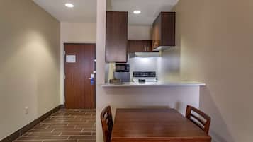Cocina compacta con microondas, estufa y armarios de madera.