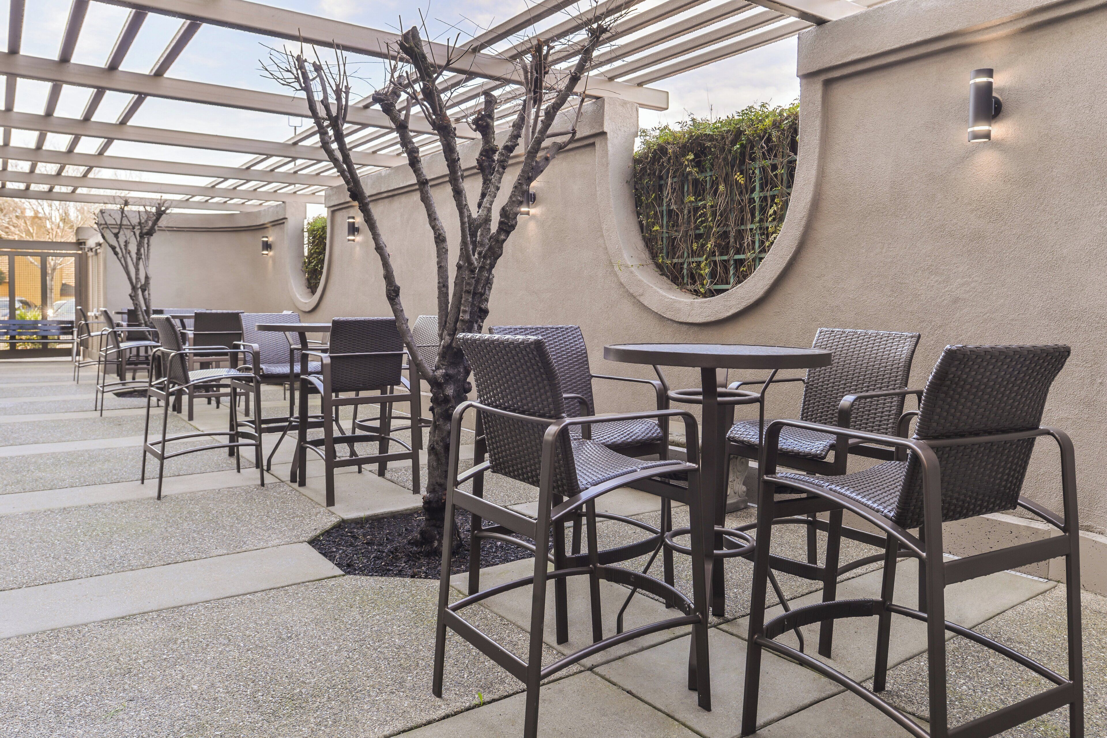 En terrasse med udendørs møbler og en pergola.