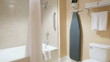 Une salle de bain équipée d’une baignoire, d’une douche, de toilettes et d’un porte-serviettes.
