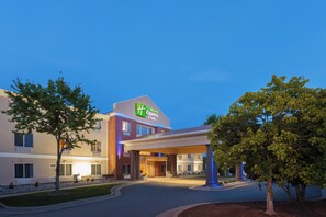 A Holiday Inn Express & Suites building with a clear sky.