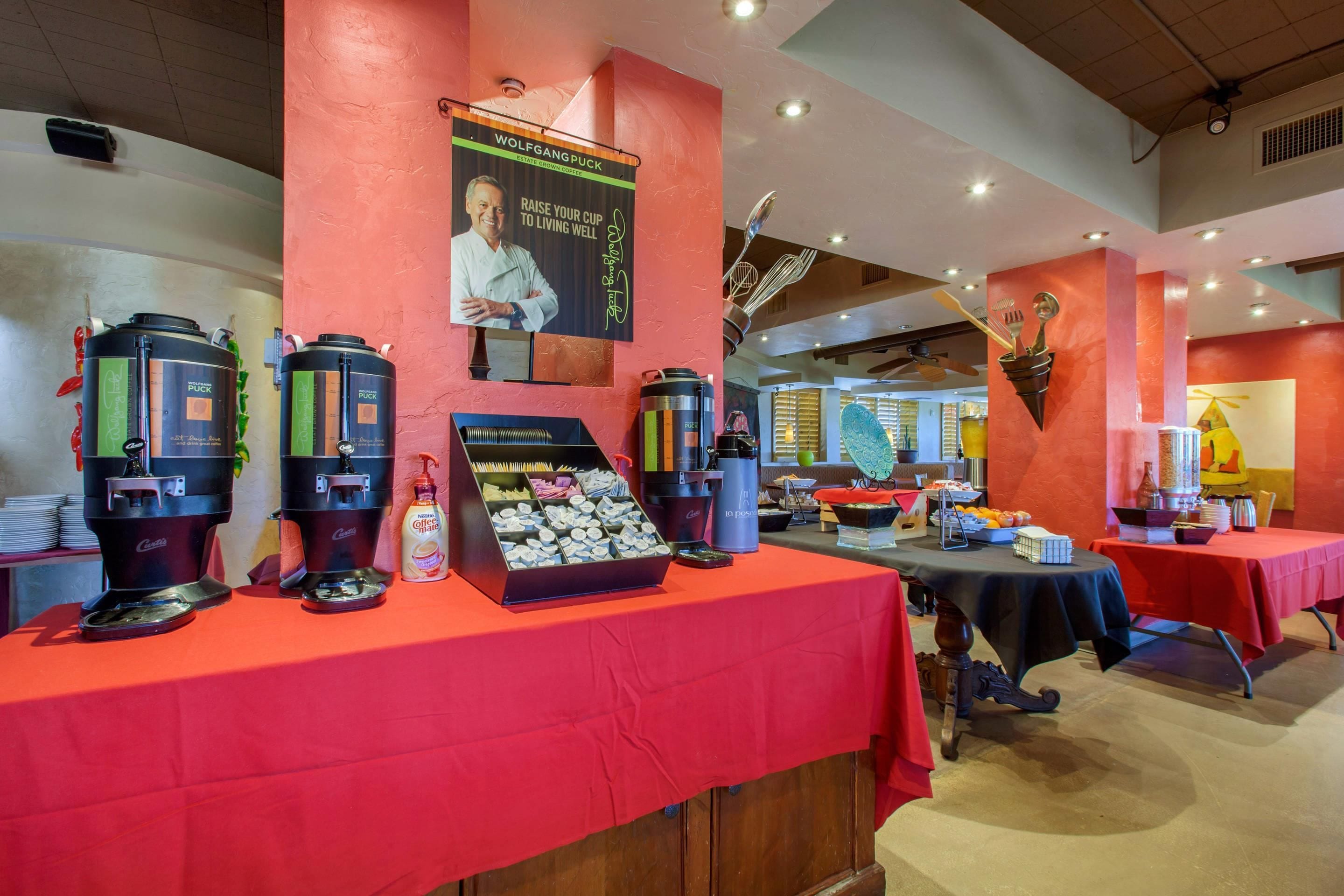 Espaço de buffet com máquinas de café e dispensador de café.