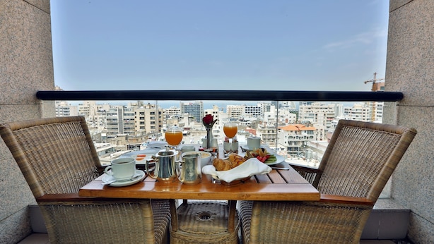 A balcony table with breakfast items and a city view. - Crowne Plaza Hotel Beirut by IHG (Beirut)