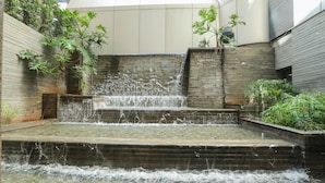 A multi-tiered water feature with cascading water, surrounded by plants and a modern architectural setting. - Crowne Plaza Hotel Beirut by IHG (Beirut)