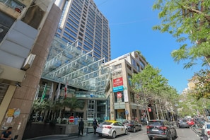 A modern building with a glass facade and a sign for 'Crowne Plaza'.