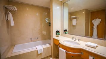 Un baño moderno con bañera, lavamanos y un espejo grande.