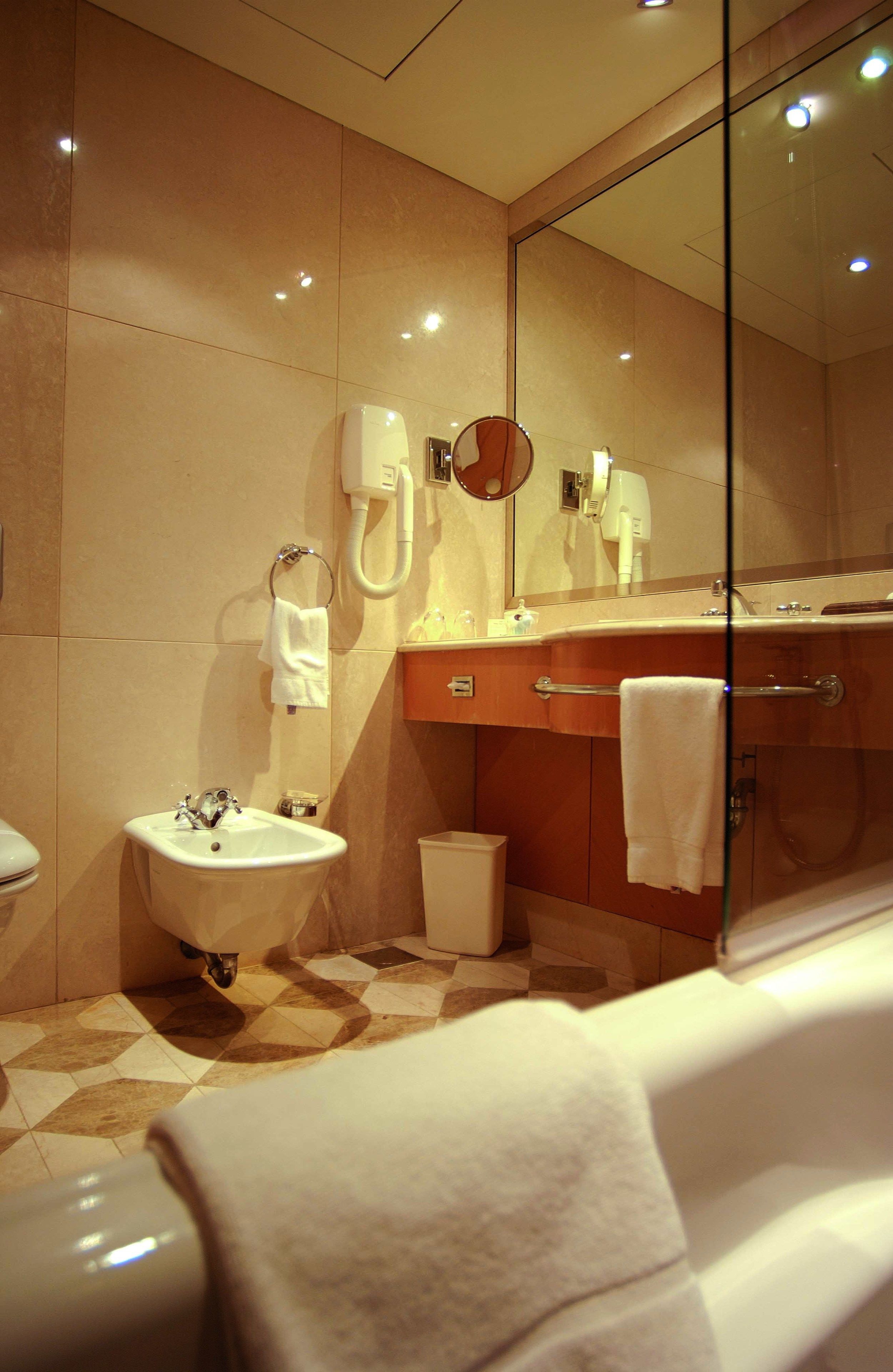 A modern bathroom with a sink, toilet, and shower.