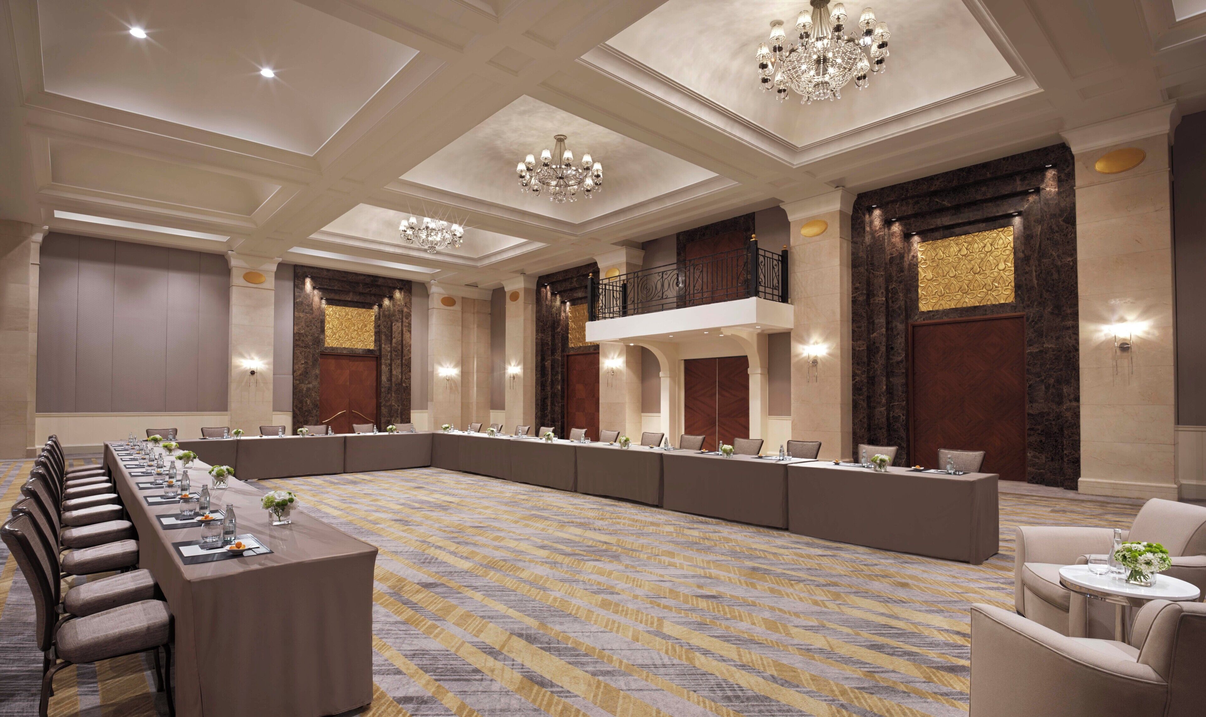 A conference room with a long table, chairs, and a patterned carpet.
