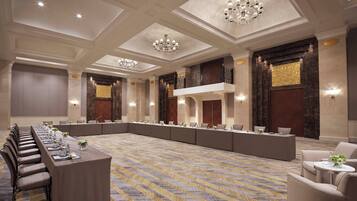 A conference room with a long table, chairs, and a patterned carpet.
