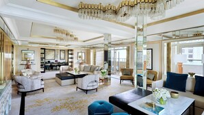 A spacious living room with a high ceiling, a dining area, and a large window providing natural light.