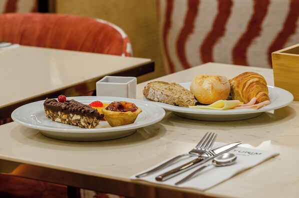 Una mesa de comedor con platos de comida, una servilleta y cubiertos.