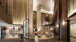 A spacious lobby with a reception desk, seating area, and a large mirror reflecting the space. - Conrad Bangkok (Bangkok)