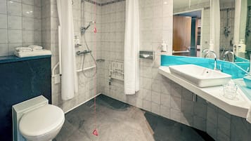 A modern bathroom with a shower, toilet, and sink.