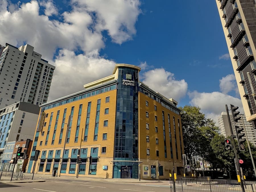 A Holiday Inn Express building with a modern design, featuring a prominent corner entrance and large windows.
