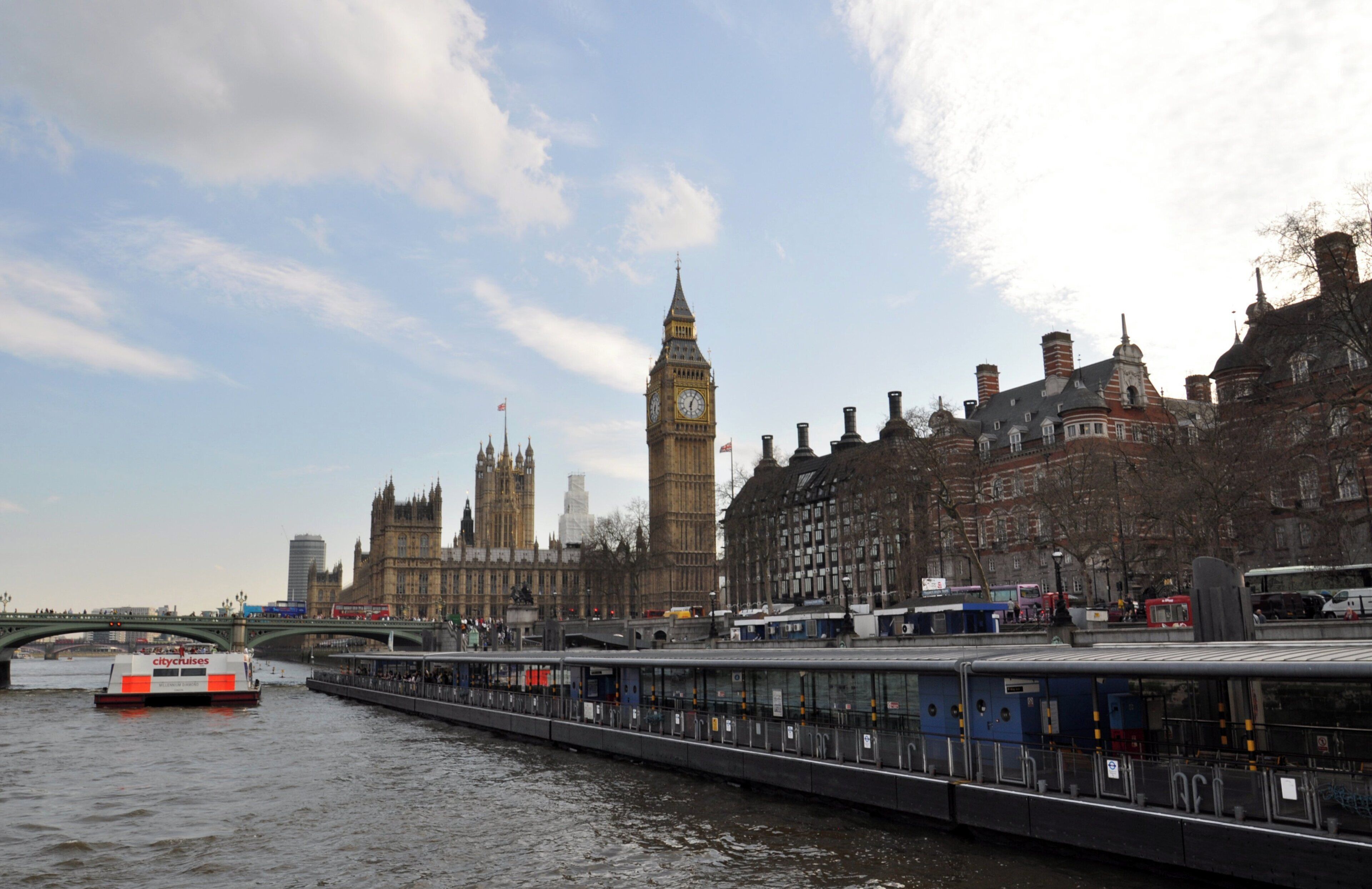 A river with a bridge and a cityscape including a prominent clock tower.