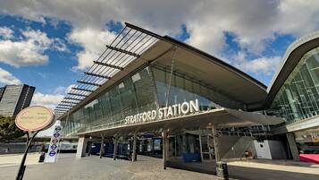 Een modern treinstation met een grote glazen gevel en een opvallend stationsbord.