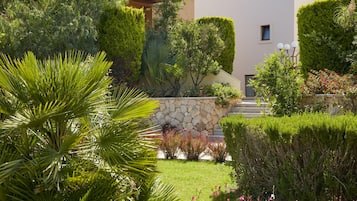 Un jardin bien entretenu, agrémenté de diverses plantes et doté d’un mur en pierre.