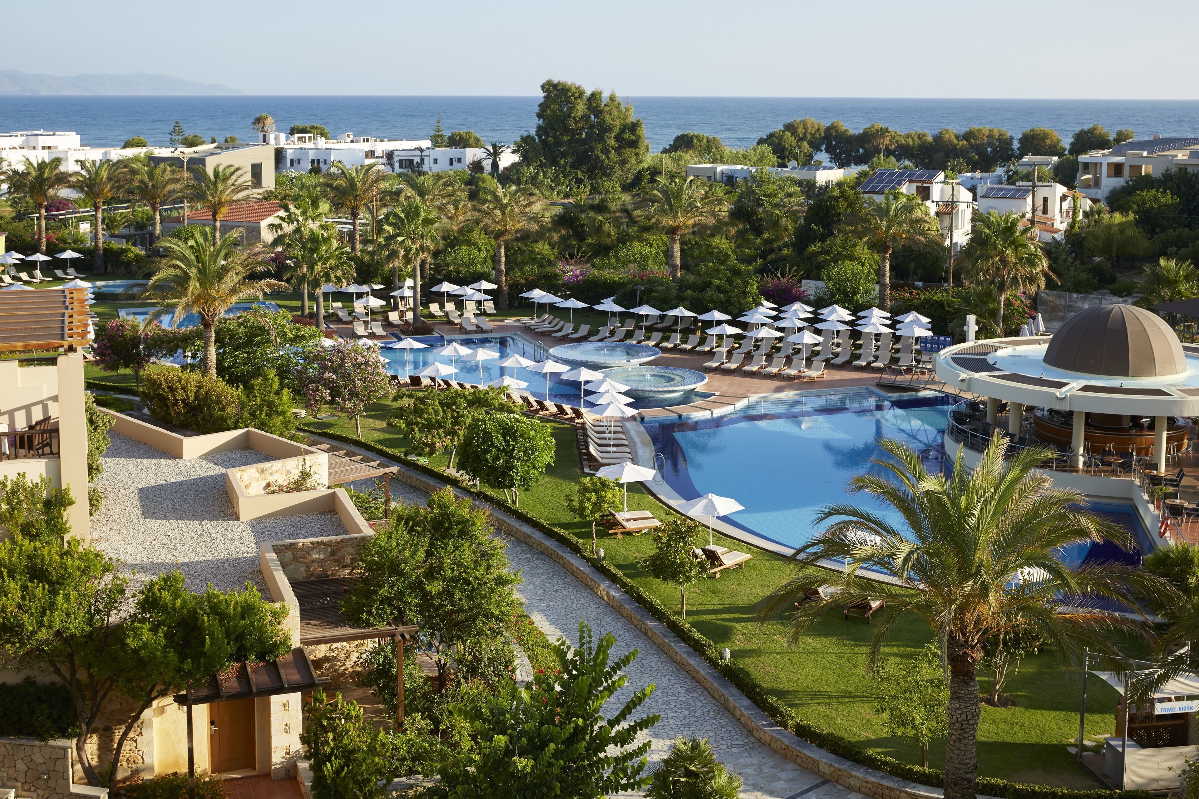 Et resort med flere swimmingpools, liggestole og palmer.