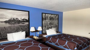 A hotel room with two beds, a nightstand with lamps, and two large black-and-white landscape paintings on the walls. - Iron Mountain Inn & Suites MI US 2 (Iron Mountain)