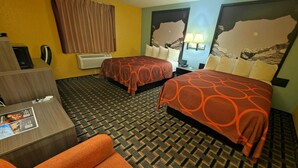 Ein Hotelzimmer mit zwei Betten, einem Schreibtisch, einem Stuhl, einem Telefon und einem Fenster mit Vorhängen.