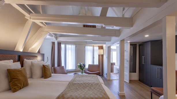 A modern hotel room with a large bed, a desk, and a wardrobe. - Hotel Avenue (Amsterdam)