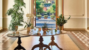 Un hall d’entrée avec une table ronde, des plantes en pot et une vue sur une colline.