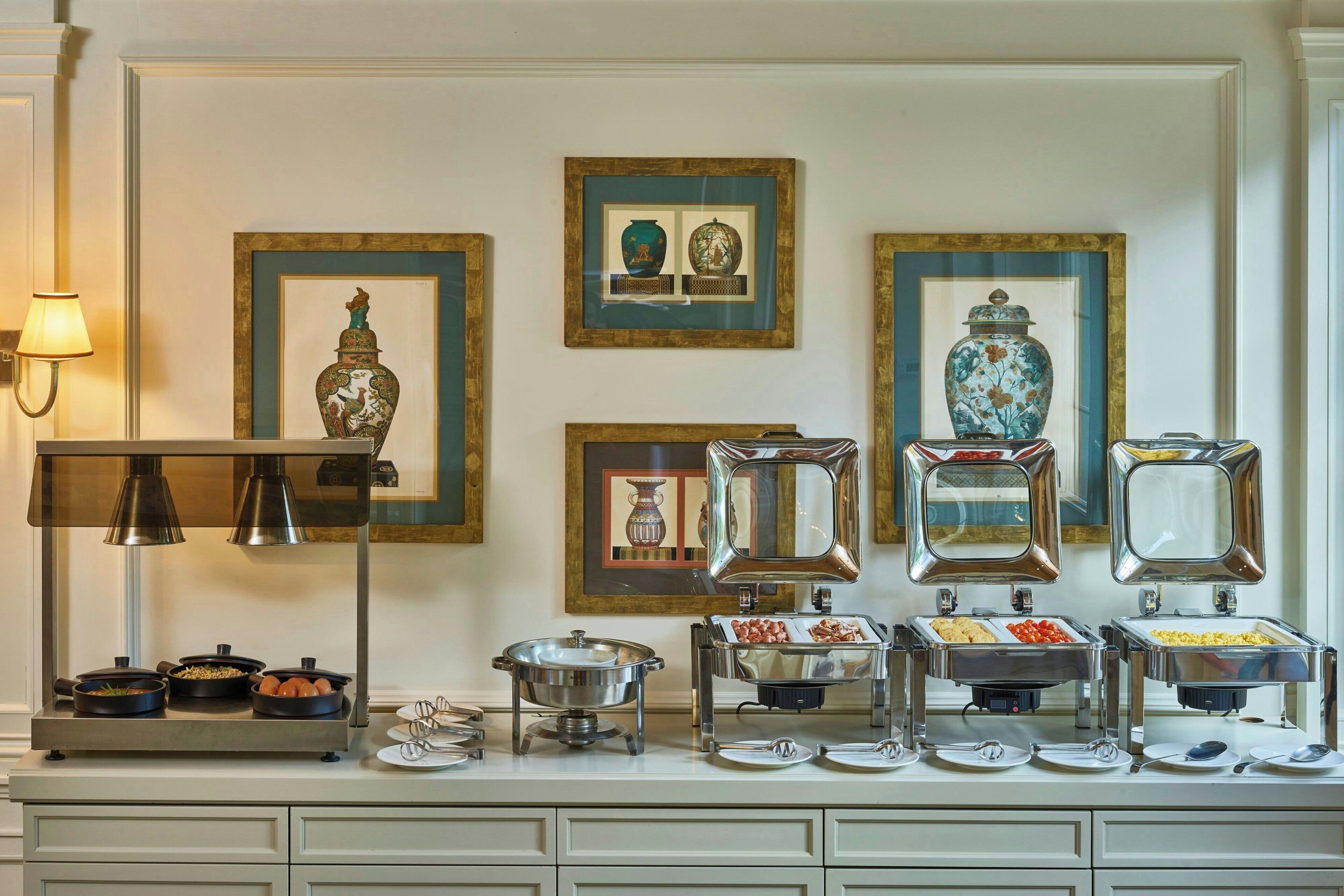 A buffet setup with various food items and decorative vases on display.