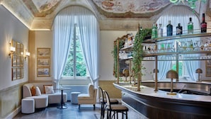A bar area with a wine rack, seating, and a chandelier. - Grotta Giusti Thermal Spa Resort Tuscany, Autograph Collection (Monsummano Terme)