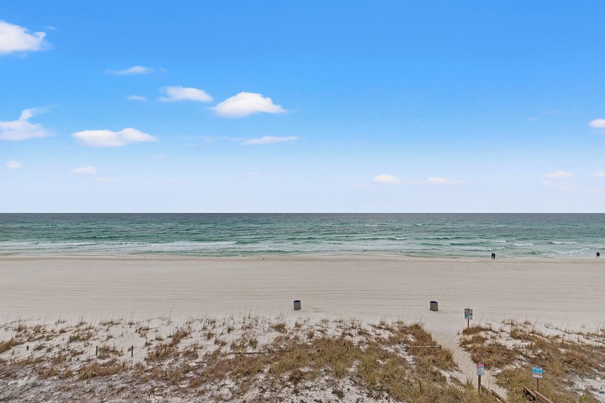 A beach with a clear sky and calm sea.