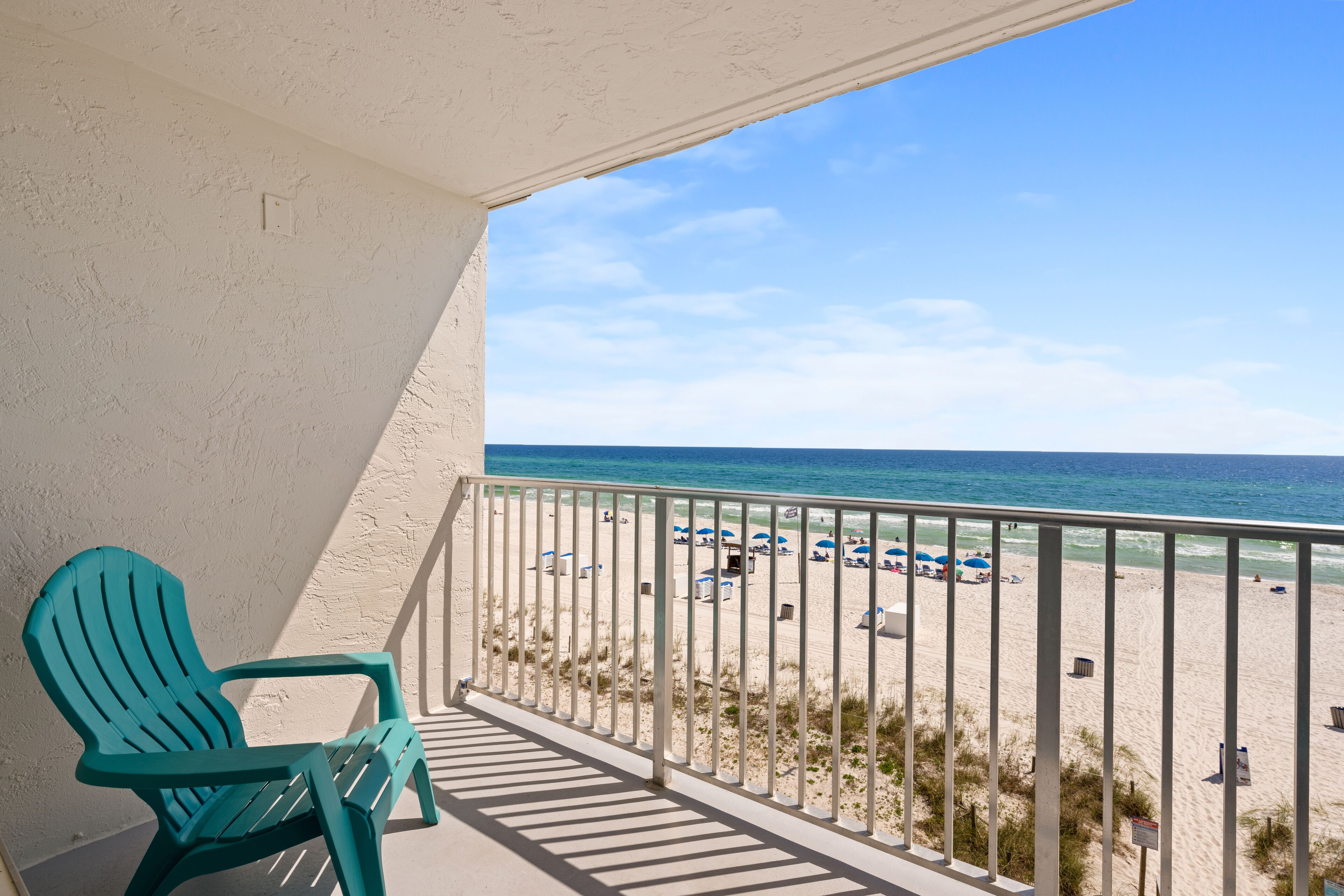 Un balcon avec vue sur une plage et l’océan.