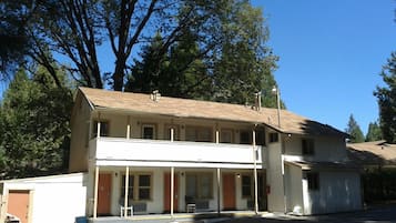 A two-story building with a flat roof, a front porch, and a small attached garage.