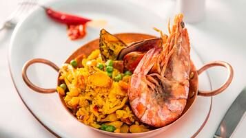Un plato de arroz con guisantes y camarones.