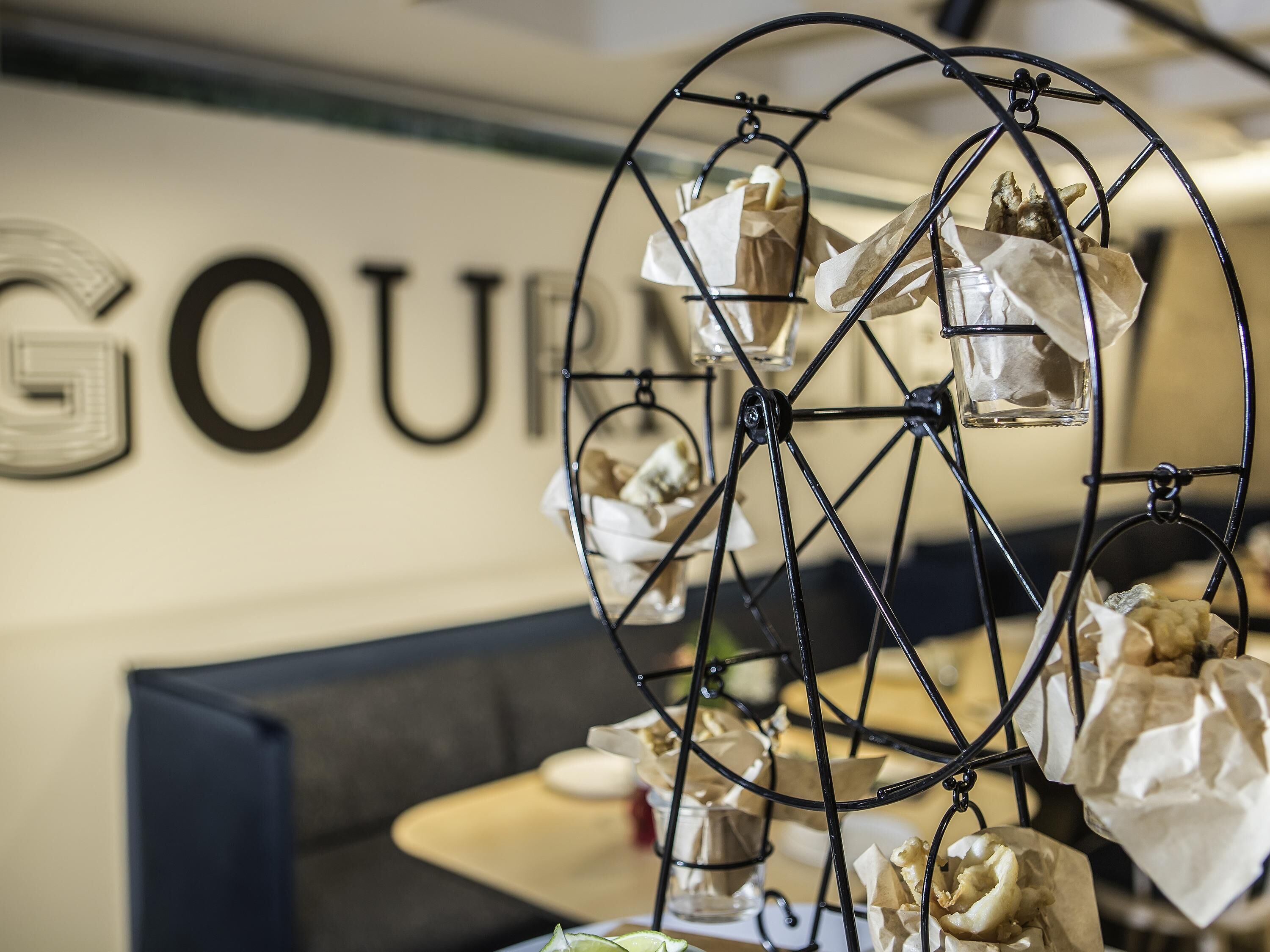 Un soporte de metal con objetos envueltos, posiblemente regalos, en una habitación con un cartel que dice 'GOUR'.
