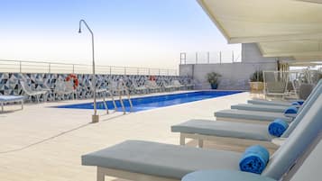 Een seizoensgebonden buitenzwembad, parasols voor strand/zwembad