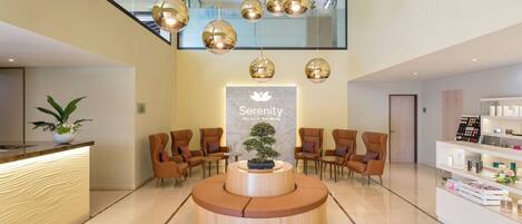 A modern reception area with a central seating area, a reception desk, and a display of products.