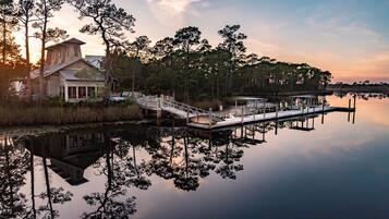 A lakeside property with a dock, a wooden house, and surrounding trees.