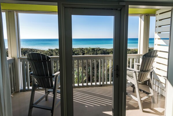 A balcony with two Adirondack chairs facing a view of the ocean. - WaterColor Inn & Resort (Santa Rosa Beach)