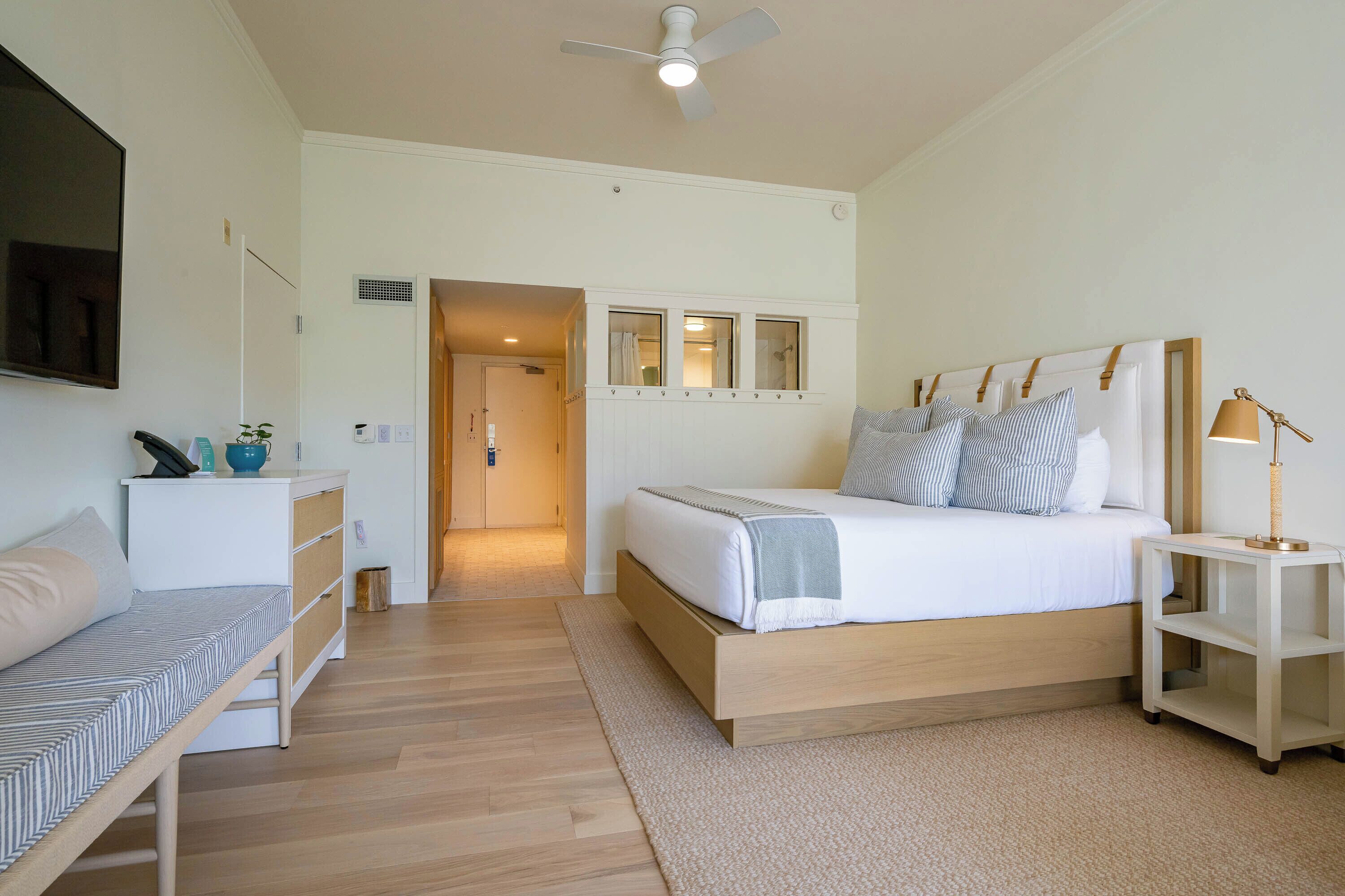 A bedroom with a bed, bedside table, and a desk with a chair.