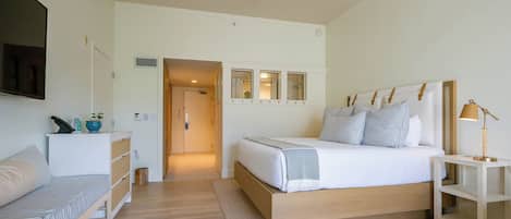 A bedroom with a bed, bedside table, and a desk with a chair.