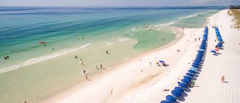 Am Strand, weißer Sandstrand, Liegestühle, Sonnenschirme