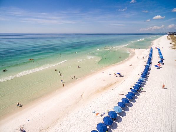 On the beach, white sand, sun loungers, beach umbrellas